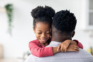 Closeup portrait of african american little girl hugging her dad, a Photo by Prostock-Studio