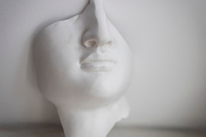 White plaster face mask sculpture, a Wallpaper Photo by Imaginarium