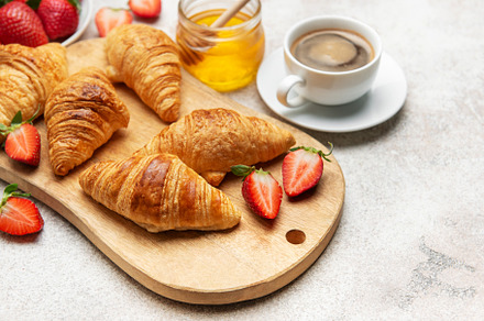 Delicious french breakfast with croissants, coffee, strawberries
