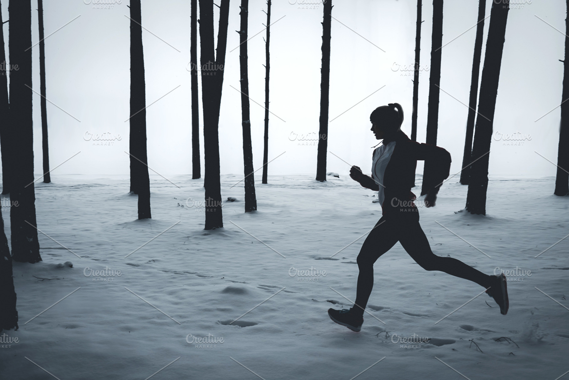 Female jogging in winter forest featuring winter, jog, and run, a Sports & Recreation Photo by supamotion