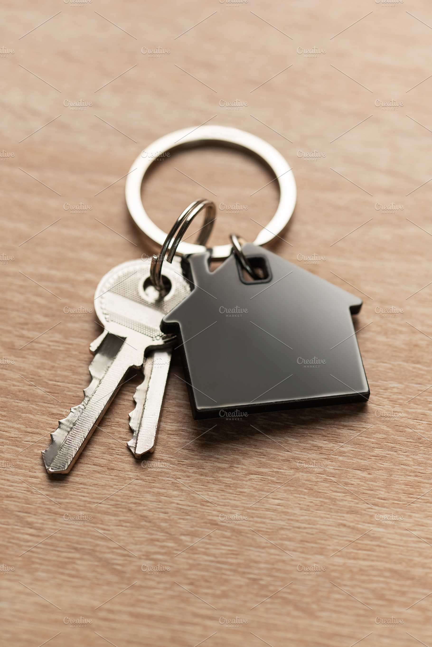 House keys with house shaped keychain on wood, a Business Photo by Olena Rudo