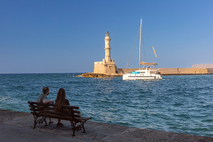 Chania lighthouse and sailboat at