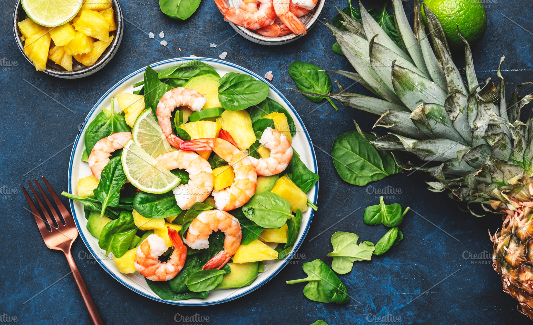 Pineapple salad with shrimps, spinach, avocado and lime on blue, a Food & Drink Photo by 5PH