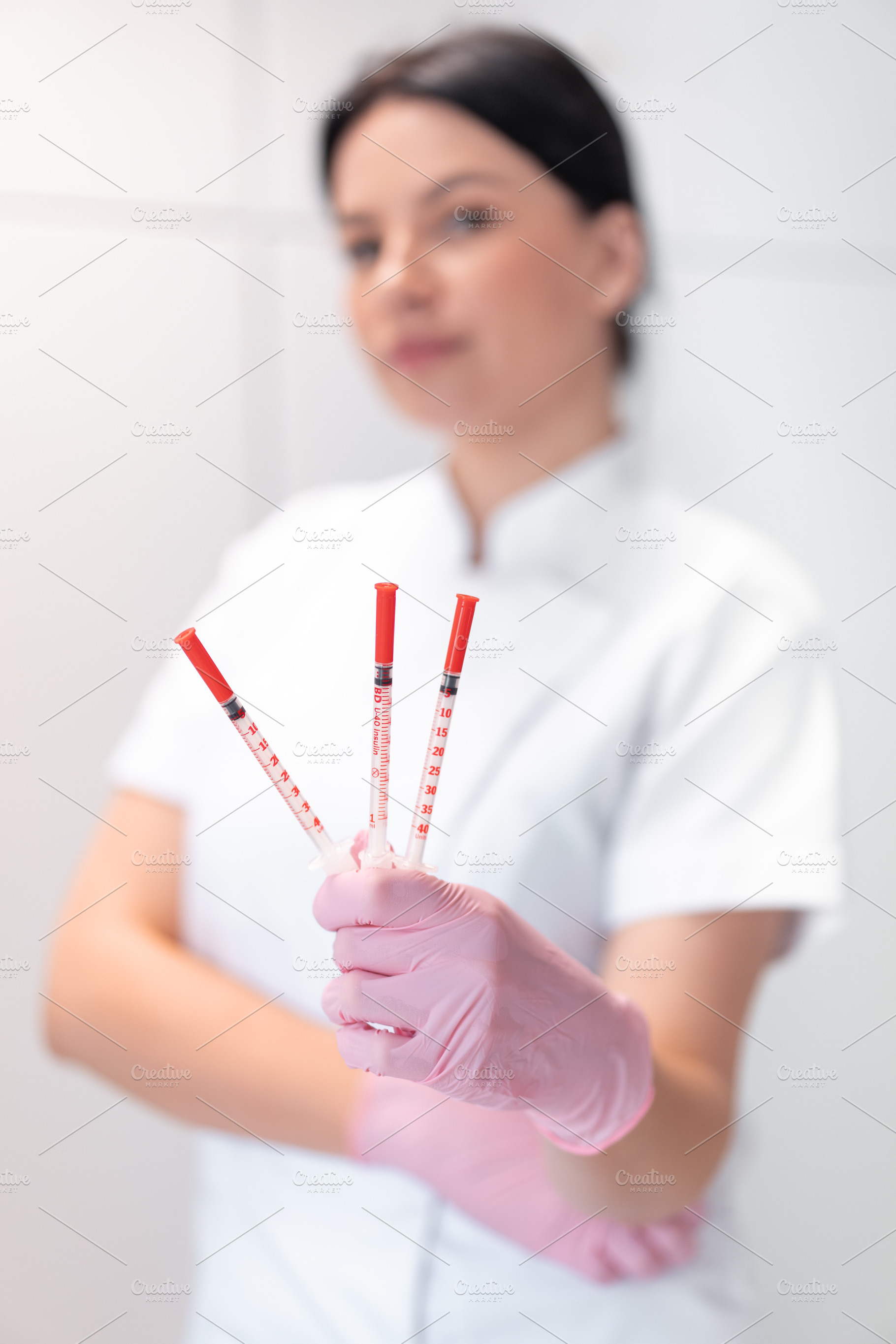 Female cosmetologist holding injection syringes in beauty spa salon, a Person Photo by andreonegin market