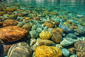 Clear water reveals colorful stones, a Photo by Pavel_design