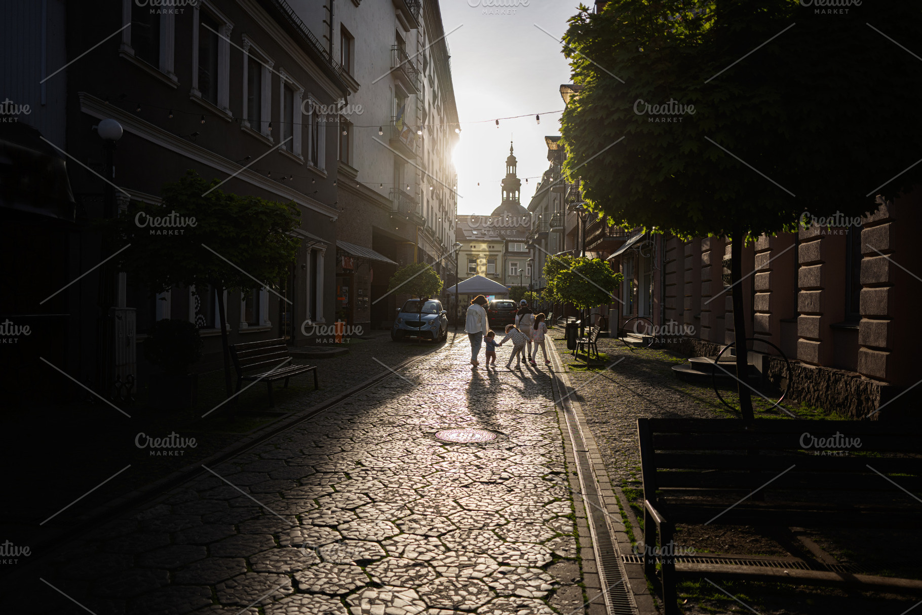 Family walking through a quiet city street at sunset with charming architecture, a Person Photo by AS photostudio