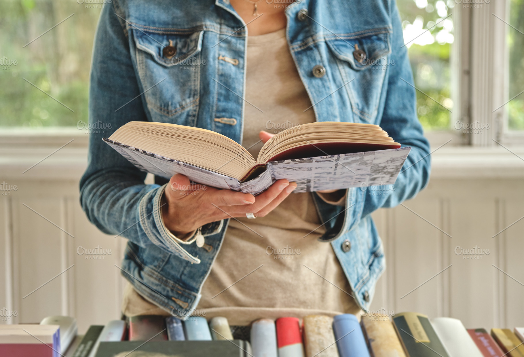 Hands holding open book in bookstore, a Person Photo by BOOCYS