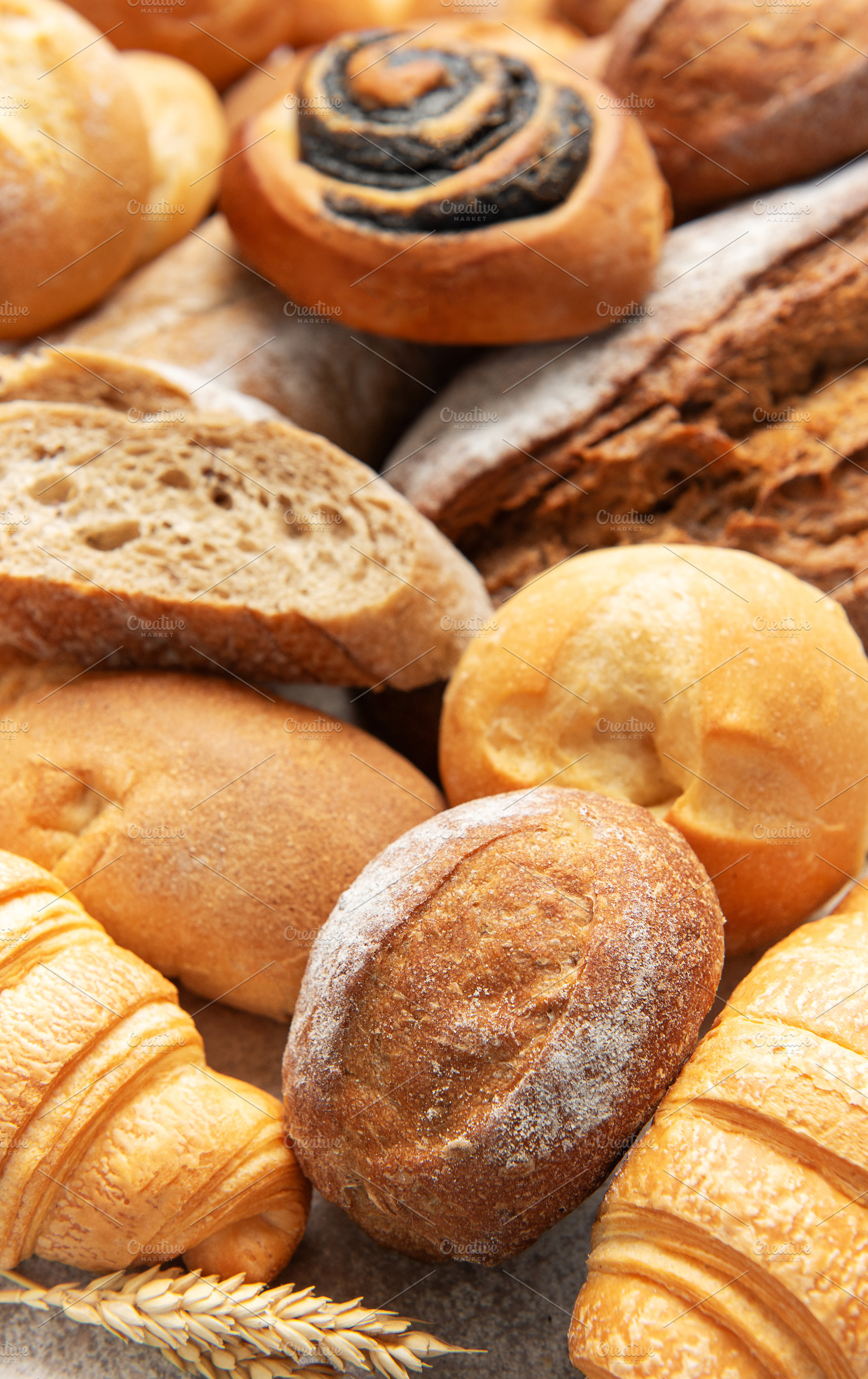 Assortment of fresh baked bread rolls and pastries, a Food & Drink Photo by Olena Rudo