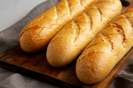 Homemade French Baguette with Garlic Filling on a wooden board,, a Food & Drink Photo by LiudmylaChuhunova