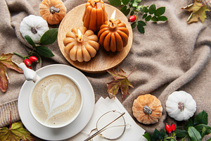 Autumn hygge flat lay with coffee and pumpkin candles