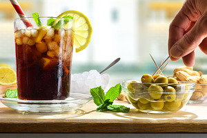 Refreshing cola drink on wooden table with snacks in room, a Food & Drink Photo by Davizro's Market