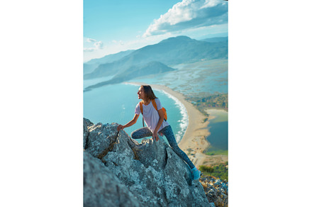 Young woman hiker climbs up on cliff, a Person Photo by vitaliymateha photography