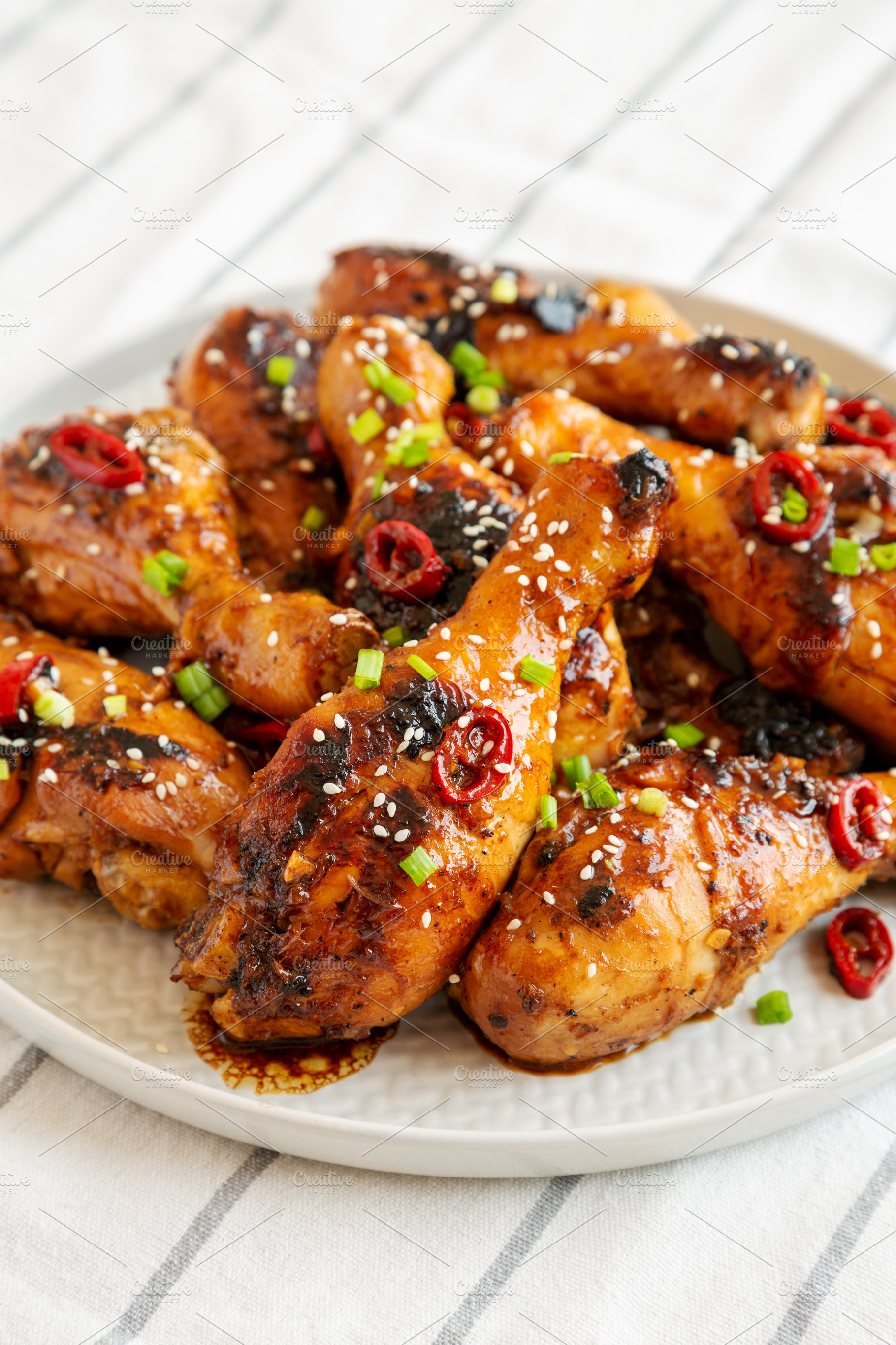 Homemade Easy Sticky Chicken Drumsticks on a Plate, side view. C, a Food & Drink Photo by LiudmylaChuhunova