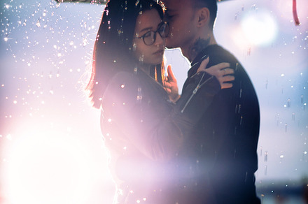 Young man and woman under an umbrell featuring city, couple, and female