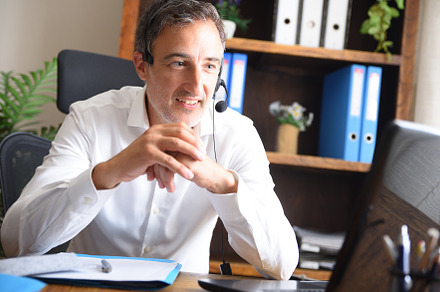 Man doing video conference with headphones in an office, a Business Photo by Davizro's Market