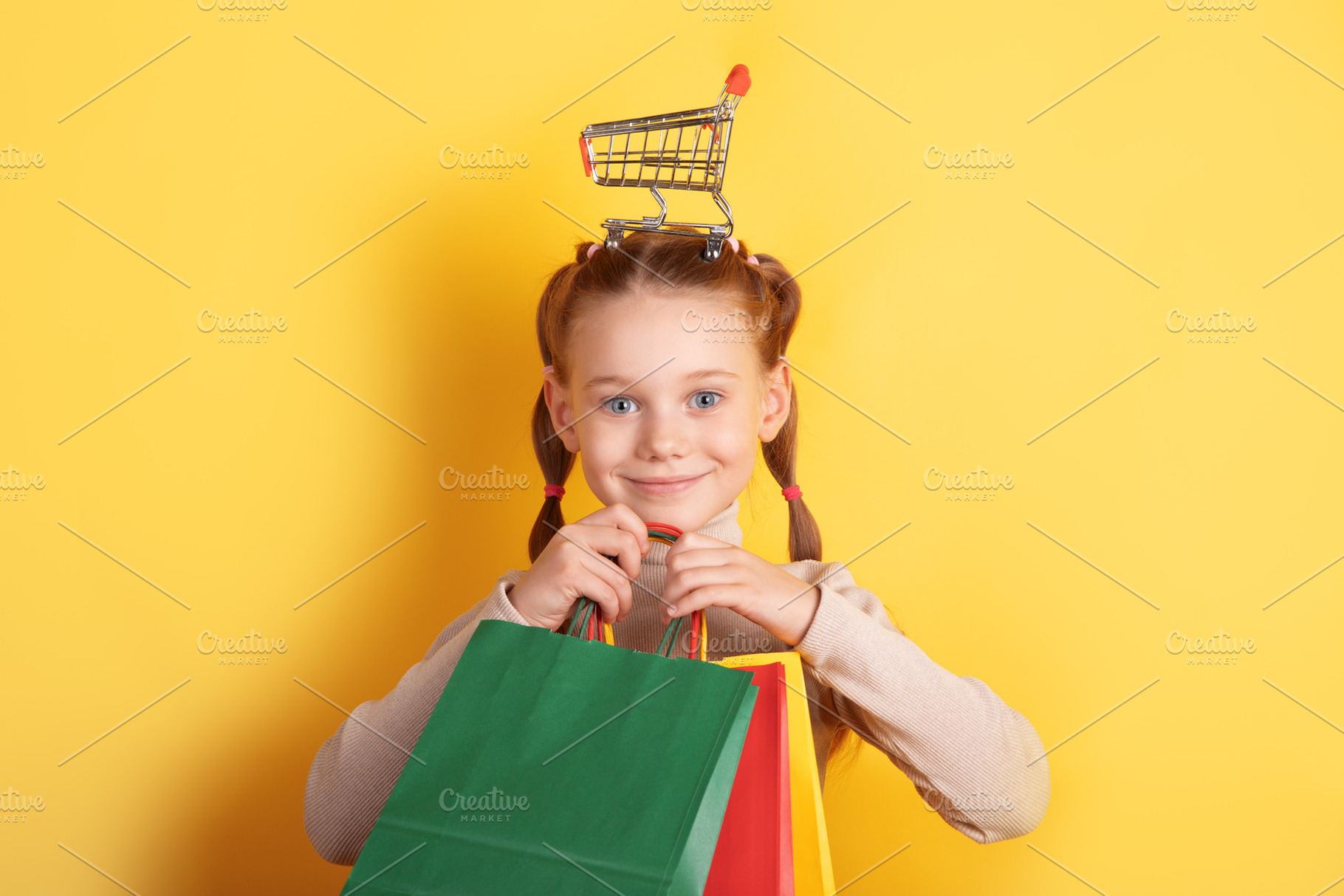 Smiling young girl holding colorful shopping bags with a miniatu, a Person Photo by Ales Munt