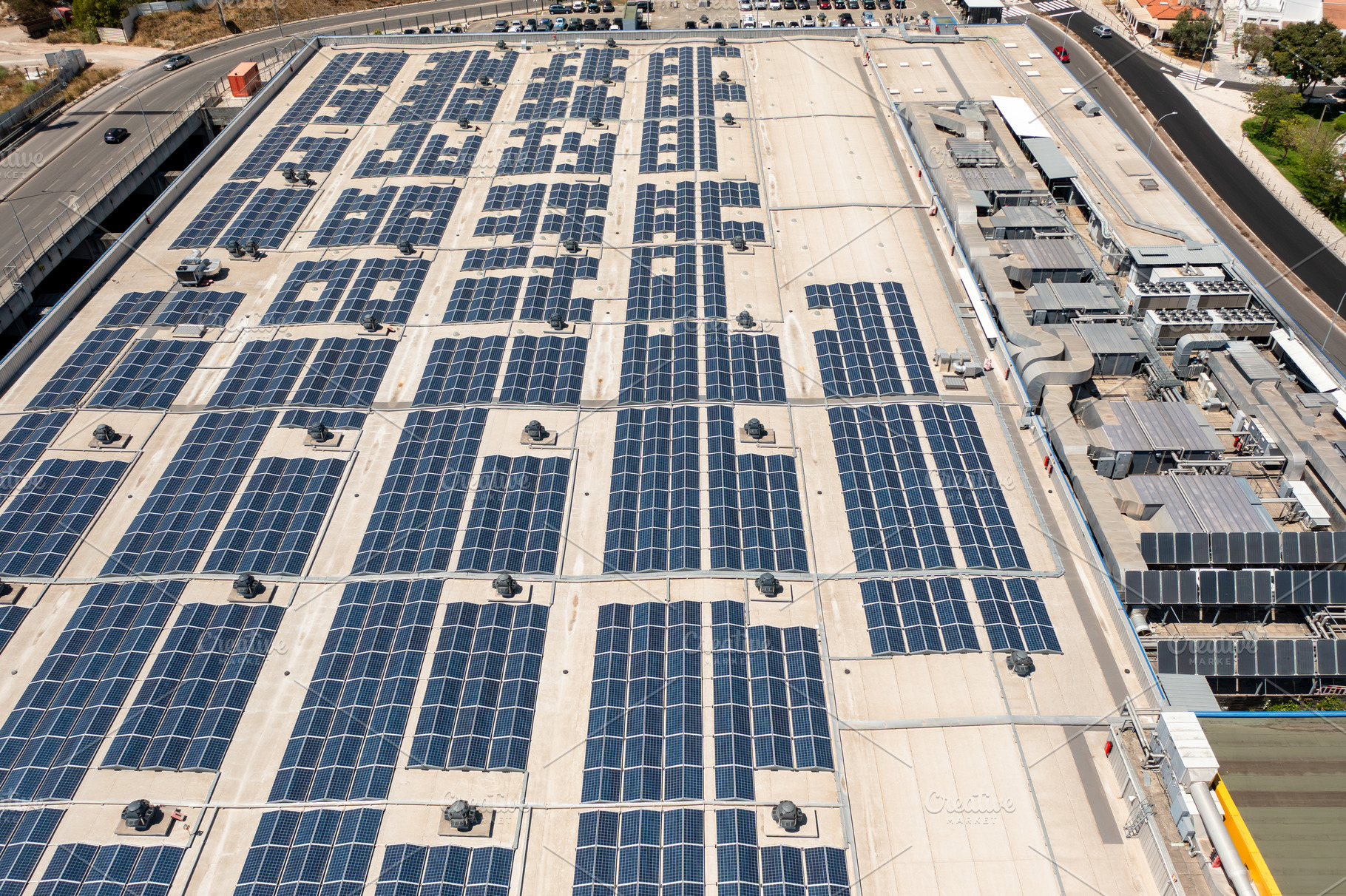 Aerial view of extensive solar panel installation on commercial rooftop, a Photo by andreonegin market