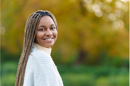African woman turning to smile at, a Person Photo by Iván Moreno STOCK PHOTO
