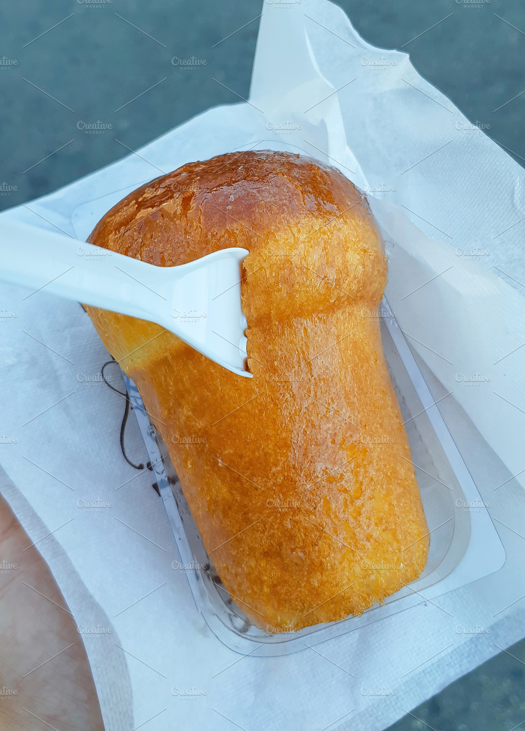 Rum baba being eaten with small white plastic fork, a Food & Drink Photo by Antonio Gravante Market