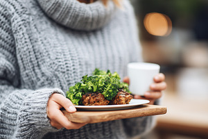 Woman in warm sweater holding plate, a Food & Drink Photo by MistyDay