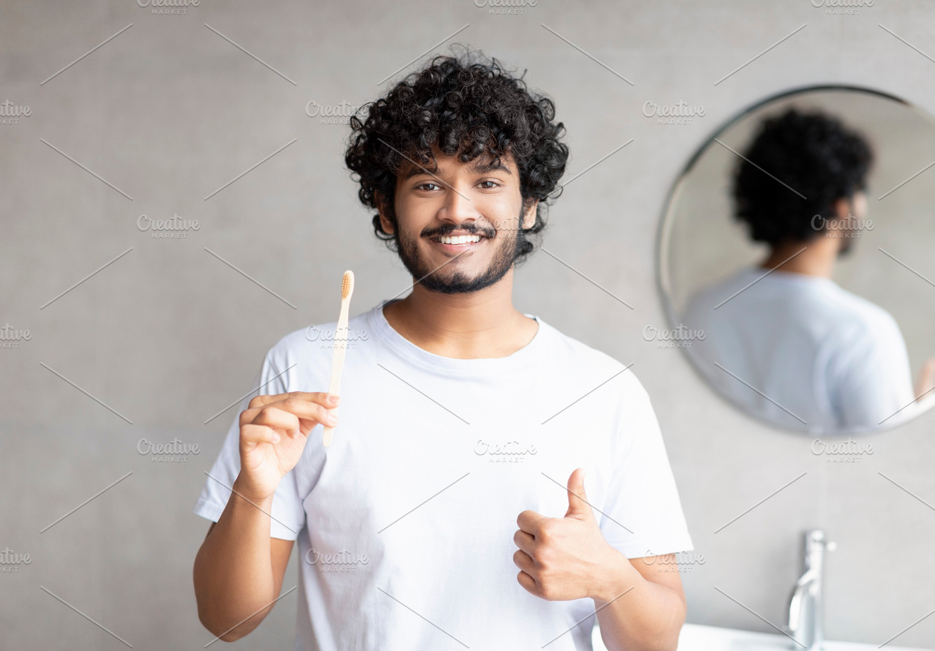 Oral care concept. Happy indian guy holding toothbrush and showing thumb up, po, a Person Photo by Prostock-Studio