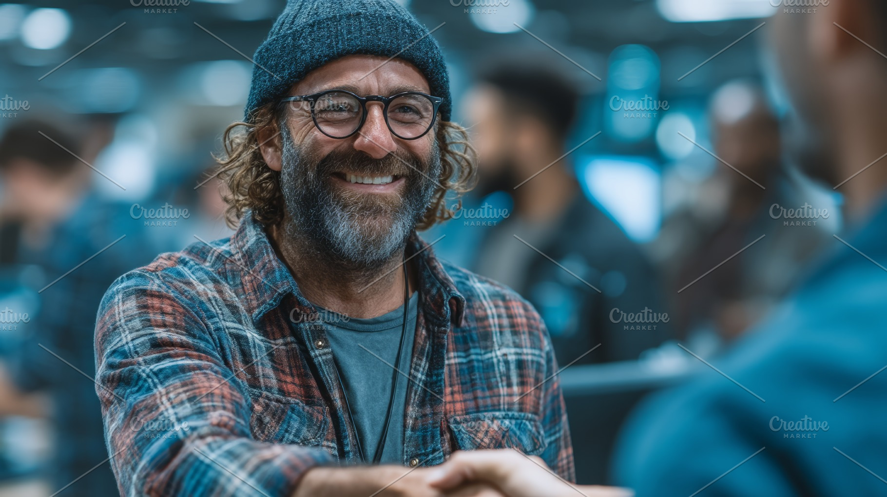 Smiling bearded man in casual attire shaking hands in a business setting, a Photo by AS photostudio