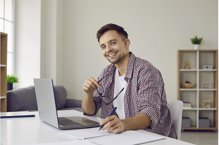 Happy student sitting at desk with, a School & Education Photo by StudioRomantic