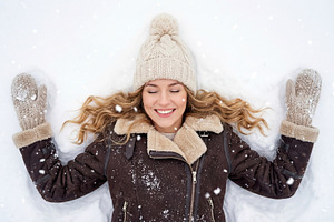 Happy Young Woman Making Snow Angel, a Person Photo by Virgo Studio