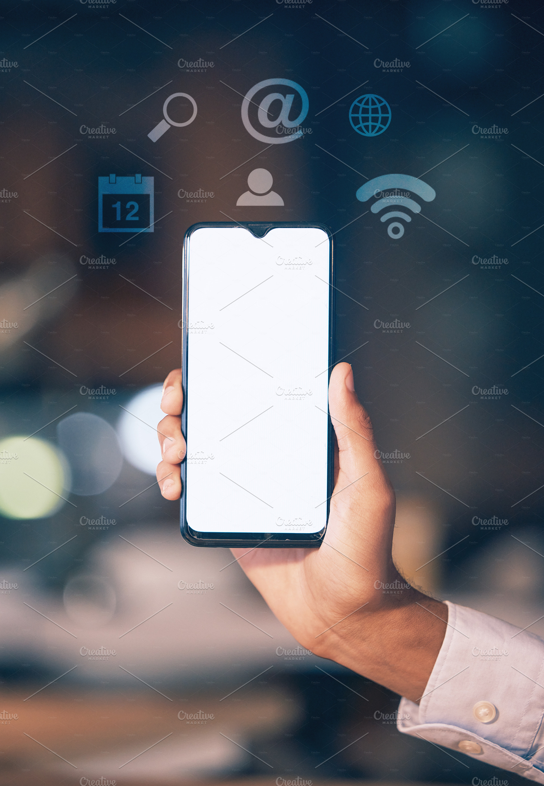 Hands, phone and mockup screen with icons at night for networking, social media or communication at the office. Hand of employee showing smartphone display for mobile app, branding or multimedia, a Photo by Peopleimages.com