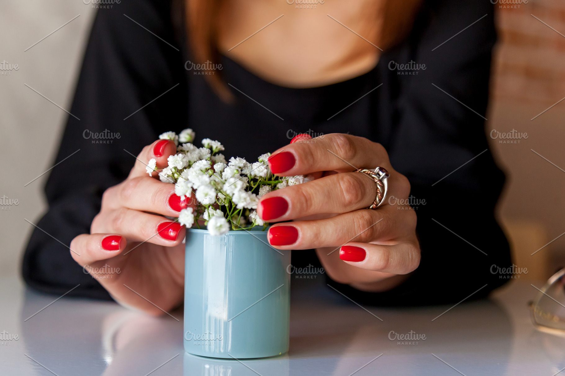 Womans hands with red nails holding small flower vase, a Person Photo by Photostock