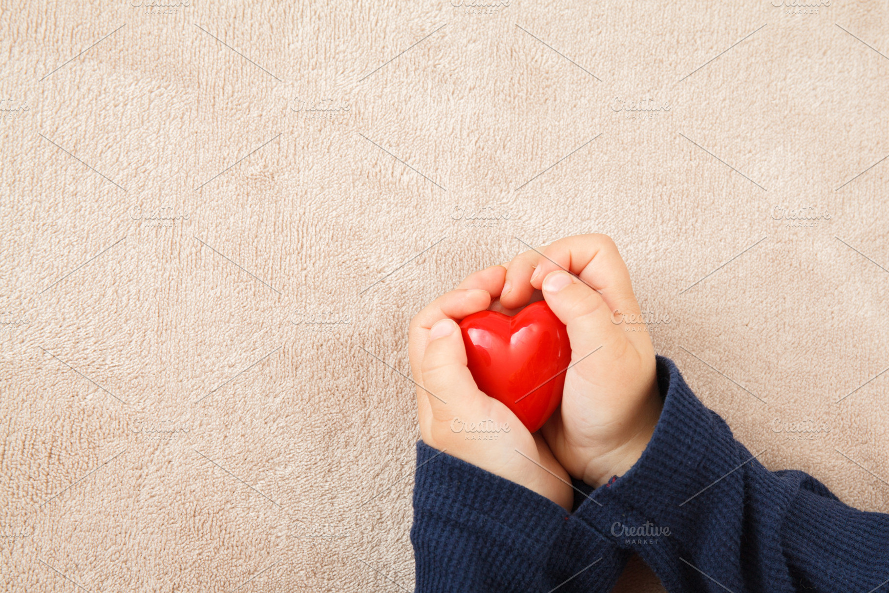child hands holding red heart, a Background Photo by OleksandrRybitskyi