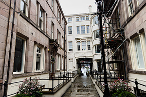 Wet narrow street and historic architecture in Liverpool, UK with stone buildin