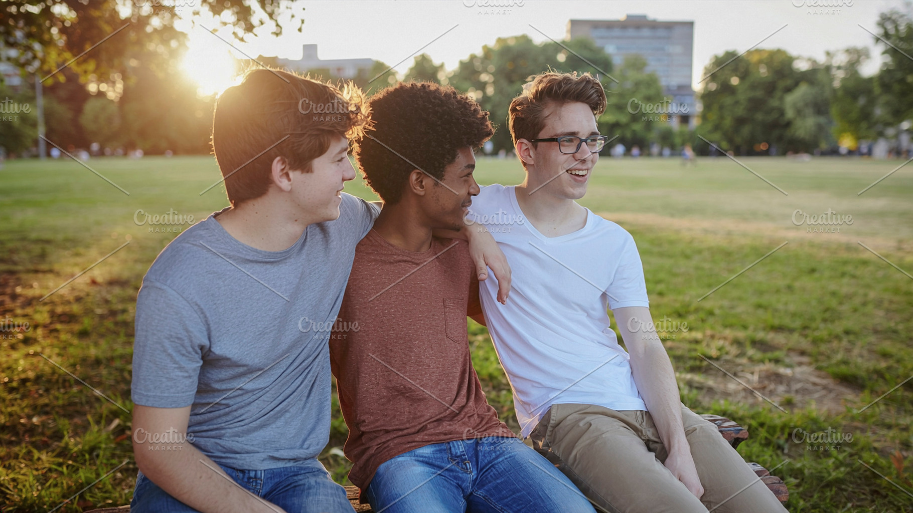 Three friends laughing together on park bench, a Photo by DanFLCreativo