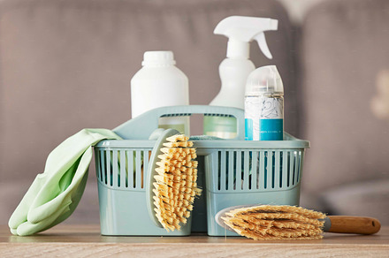 Product, basket and cleaning with a brush, supplies or detergent on a wooden table surface for housework. Bacteria, living room and empty room with a container of disinfectant in a house or home, a Photo by Peopleimages.com