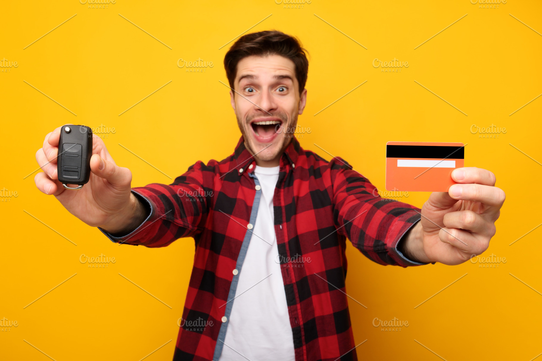 Excited Man Showing Car Key And Credit Card, Yellow Background, a Photo by Prostock-Studio