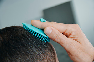 man in the bathroom combing his hair, a Photo by Nito