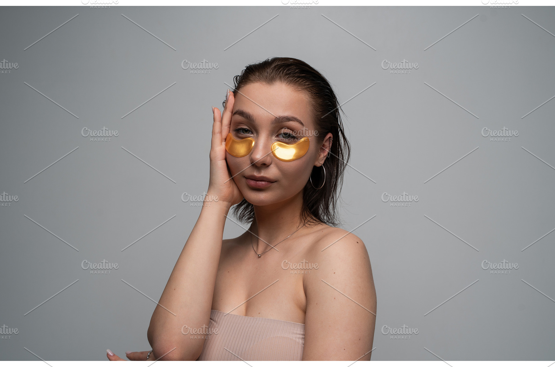 Young woman applying golden eye, a Health & Medical Photo by volodymyrshtun13795