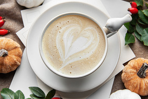 Autumn latte art heart with fall pumpkins and leaves
