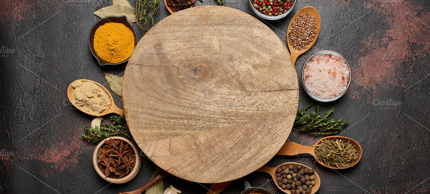 Spices around a round wooden board. Turmeric, cloves, anise, pep, a Food & Drink Photo by ndanko