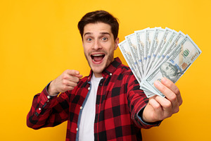 Excited young man holding a lot of money cash