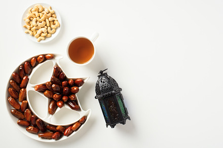 Holy month of Ramadan concept. Ramadan lantern, dates, nuts, food on white tabl, a Holiday Photo by photoguns