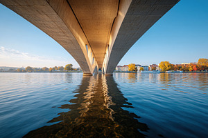 Underneath a modern bridge with autumn reflections, an Architecture Photo by AlyaAnd