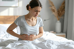 Woman Experiencing Stomach Pain Sitting in Bed, a Health & Medical Photo by Davizro's Market