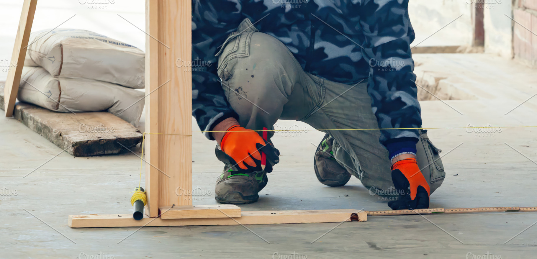 Construction worker measuring and marking guidelines on concrete floor, an Industrial Photo by Antonio Gravante Market