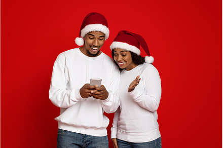 Cheerful black couple in Santa hats, a Person Photo by Prostock-Studio
