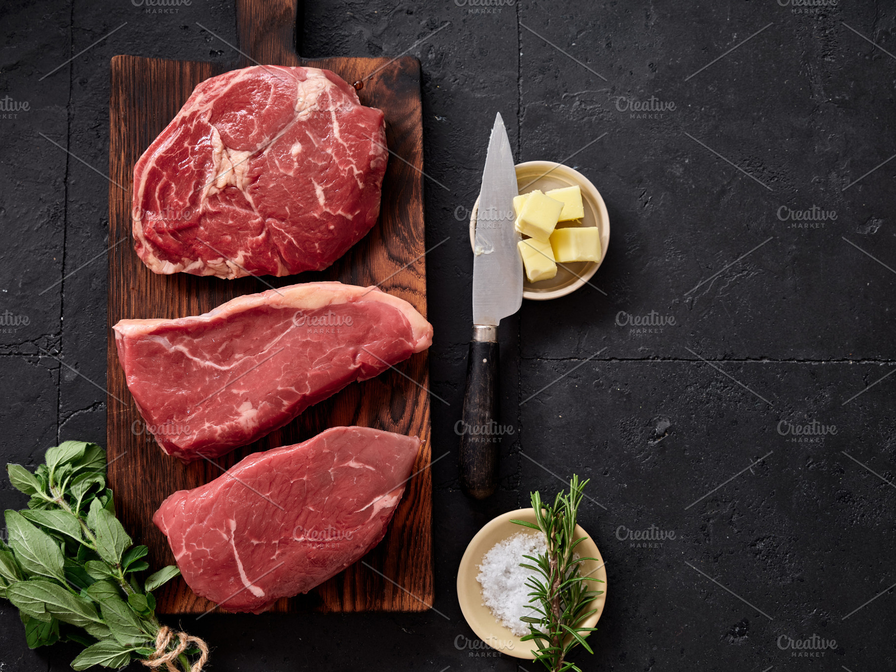 Fresh raw rib-eye, roast beef, flank, and rump steak displayed on a wooden cutt, a Food & Drink Photo by Asya Nurullina