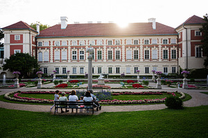 Historic Lancut palace garden with visitors admiring the landscape at sunset, a Photo by AS photostudio