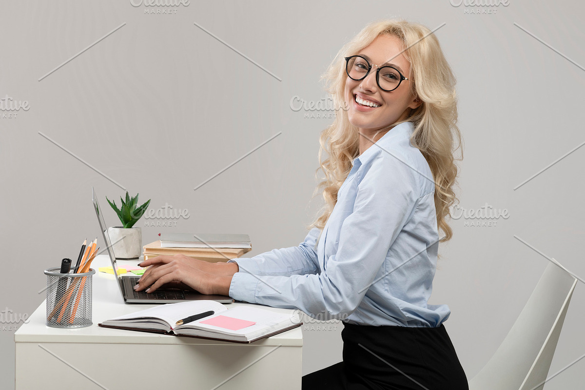 Entrepreneurship and own business. Happy businesswoman sitting at workplace and, a Photo by Prostock-Studio (Photo 2 of 2)