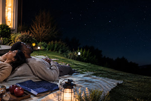 Couple stargazing under night sky pr, a Photo by Dvoevnore photos