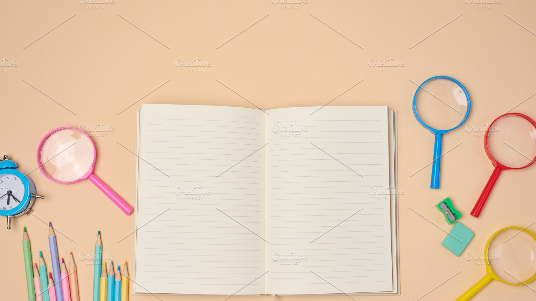 Top view of an open notebook with pastel-colored pencils, green, a School & Education Photo by ndanko